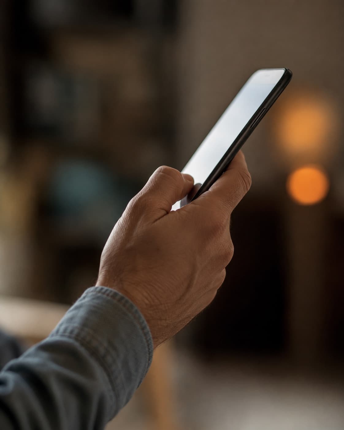 Mão segurando o celular, com o polegar deslizando na tela para passar o slide